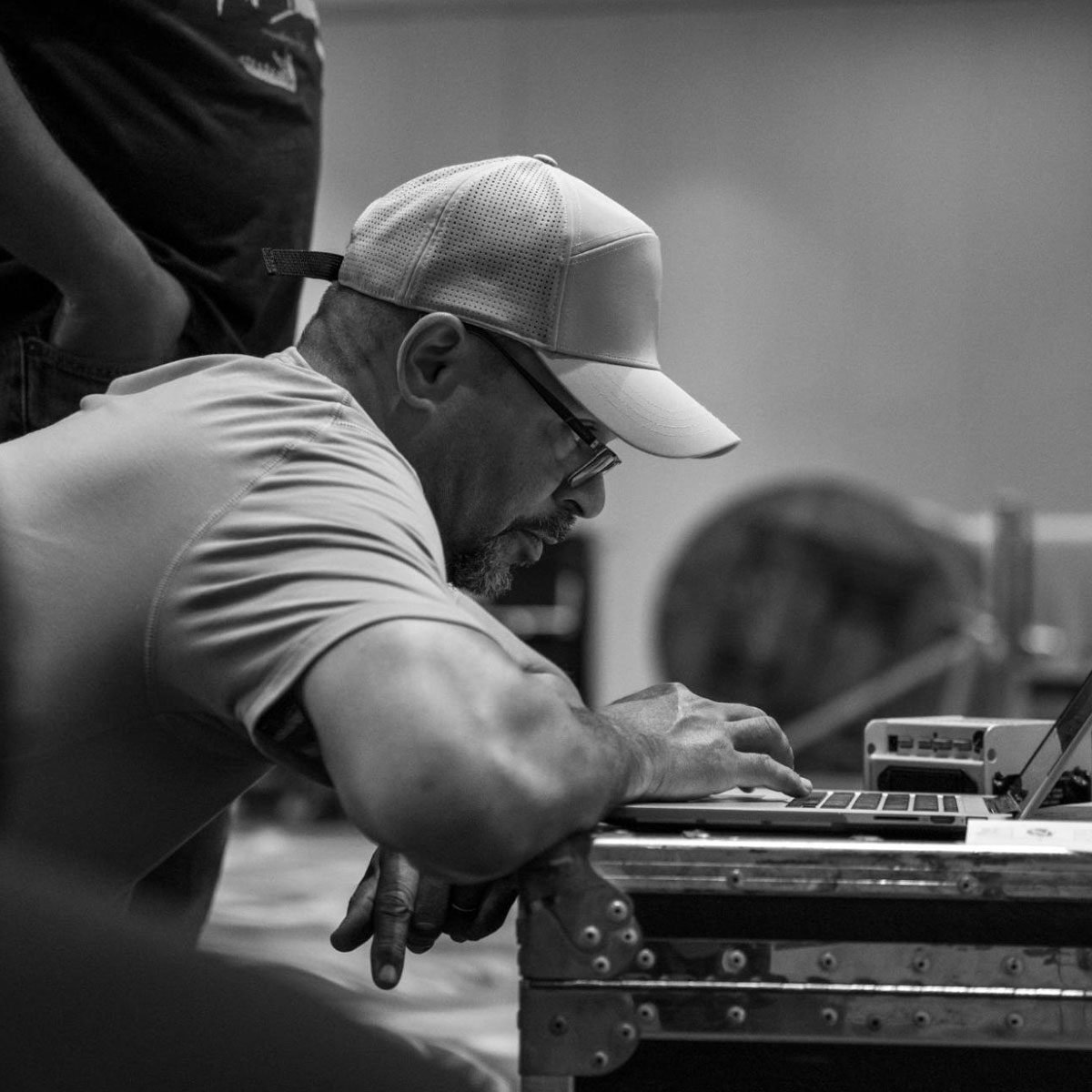 Man hunched over, working on his laptop. 